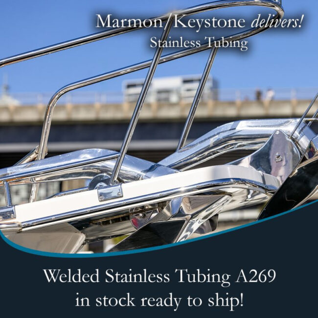 Marmon Keystone Close-up of polished stainless steel tubing on a boat railing with promotional text for Marmon/Keystone welded stainless tube and pipe, A269. In-stock metals, ready to ship from your trusted supply chain distributor. Bridge and sky in the background.
