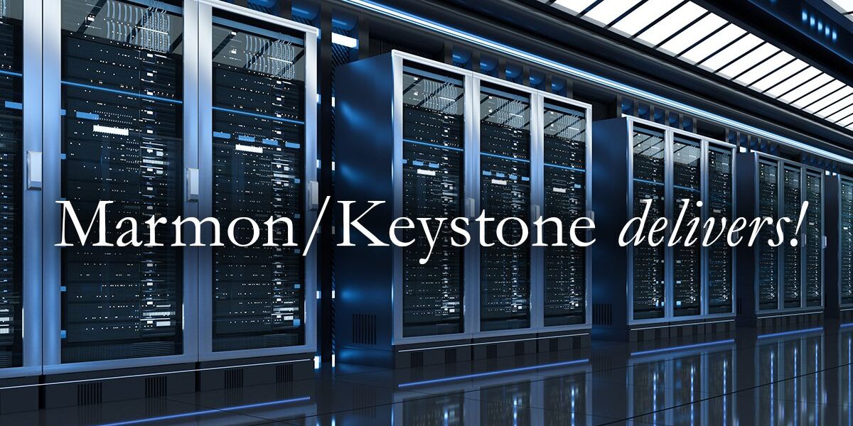 Marmon Keystone A row of server racks with blue LED lights in a modern data center. Overlaid text reads, "Marmon/Keystone delivers! For Data Centers.